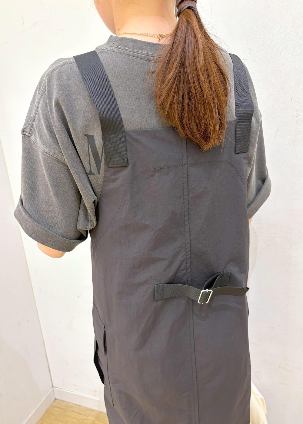 ブラック系のサンダル、グレー系のジャンパースカート、グレー系のTシャツ/カットソーを着用したレディースの夏コーディネートの6枚目の写真