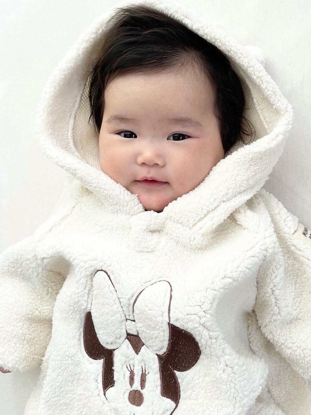 ホワイト系のロンパース、ホワイト系のレギンス/スパッツを着用したキッズの冬コーディネートの3枚目の写真