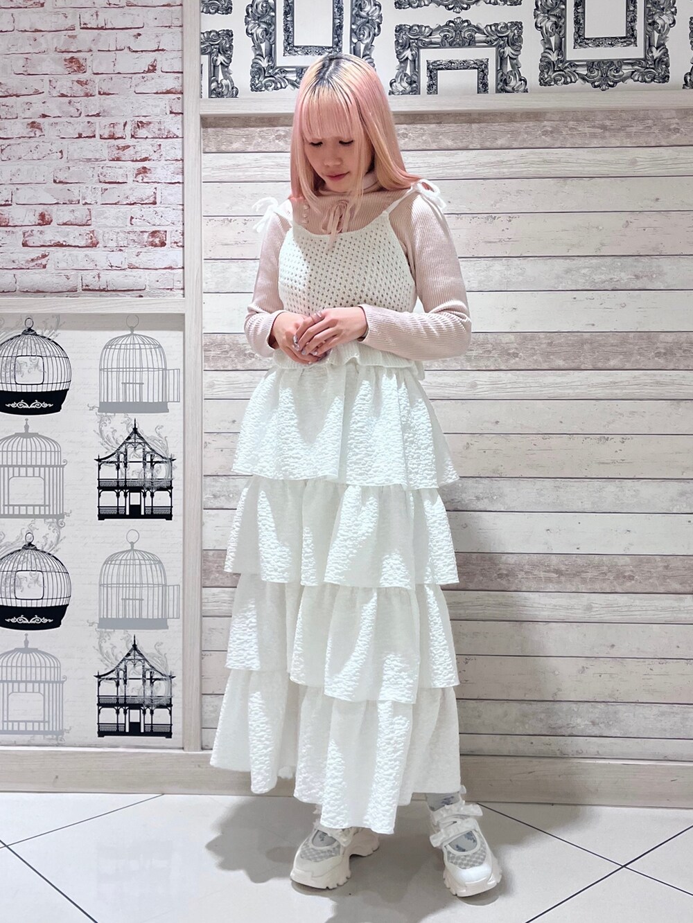 ピンク系のニット/セーター、ホワイト系のキャミソール、ホワイト系のスカートを着用したレディースの冬コーディネートの2枚目の写真