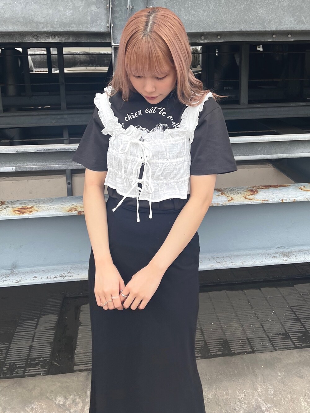 ホワイト系のベスト、グレー系のTシャツ/カットソー、ブラック系のスカートを着用したレディースの春コーディネートの3枚目の写真