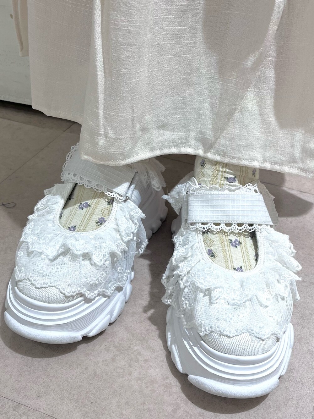 ホワイト系のカーディガン/ボレロ、グレー系のニット/セーター、ホワイト系のスカートを着用したレディースの秋コーディネートの9枚目の写真