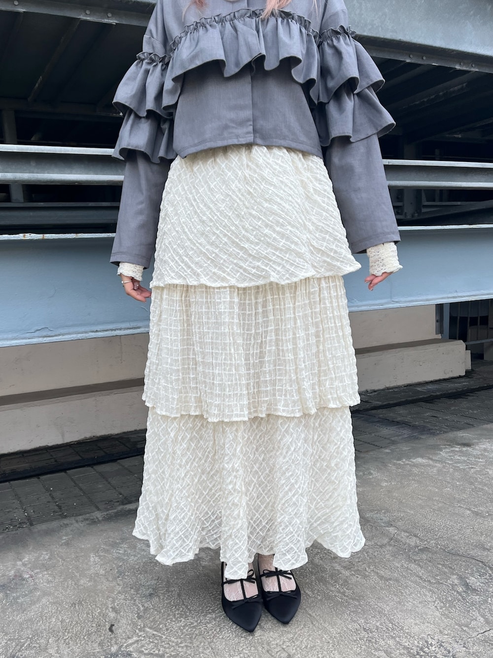 グレー系のテーラードジャケット、ホワイト系のTシャツ/カットソー、ホワイト系のスカートを着用したレディースの冬コーディネートの4枚目の写真