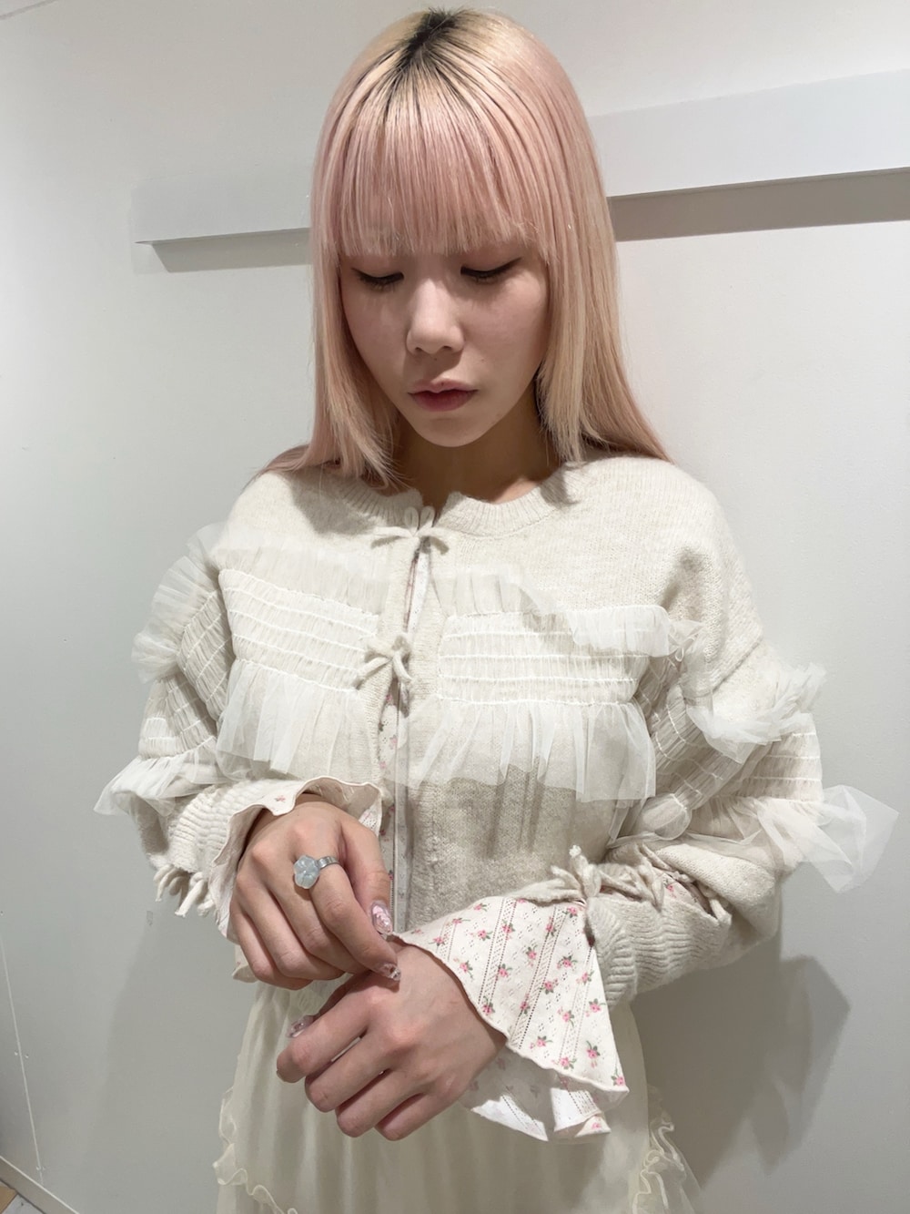 ホワイト系のスカート、ホワイト系のカーディガン/ボレロ、ピンク系のTシャツ/カットソーを着用したレディースの冬コーディネートの4枚目の写真