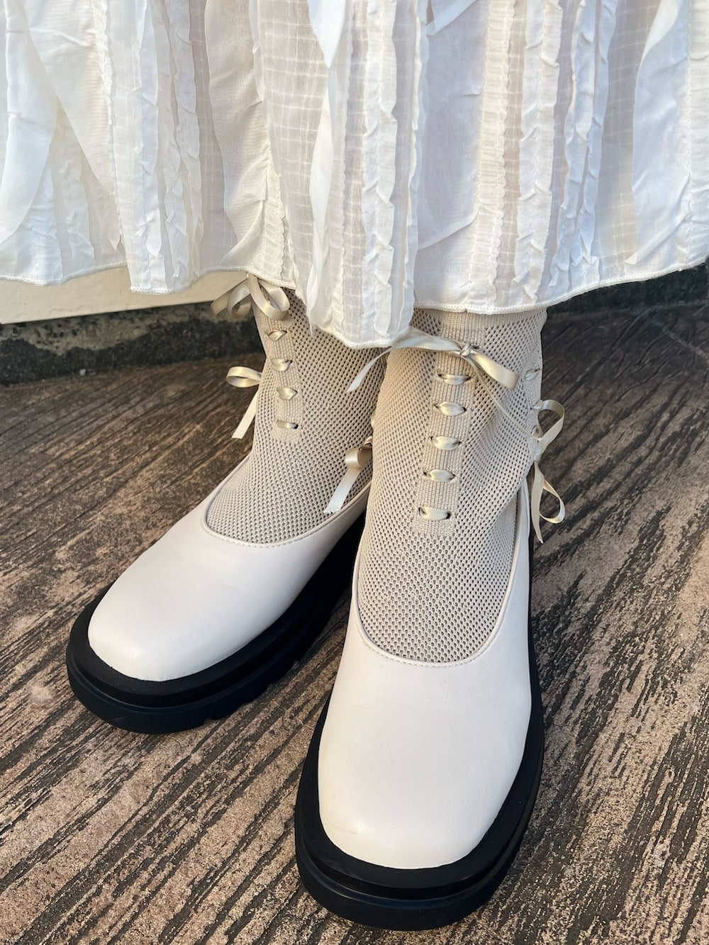 ブラック系のカーディガン/ボレロ、ホワイト系のTシャツ/カットソー、ホワイト系のスカートを着用したレディースの秋コーディネートの6枚目の写真