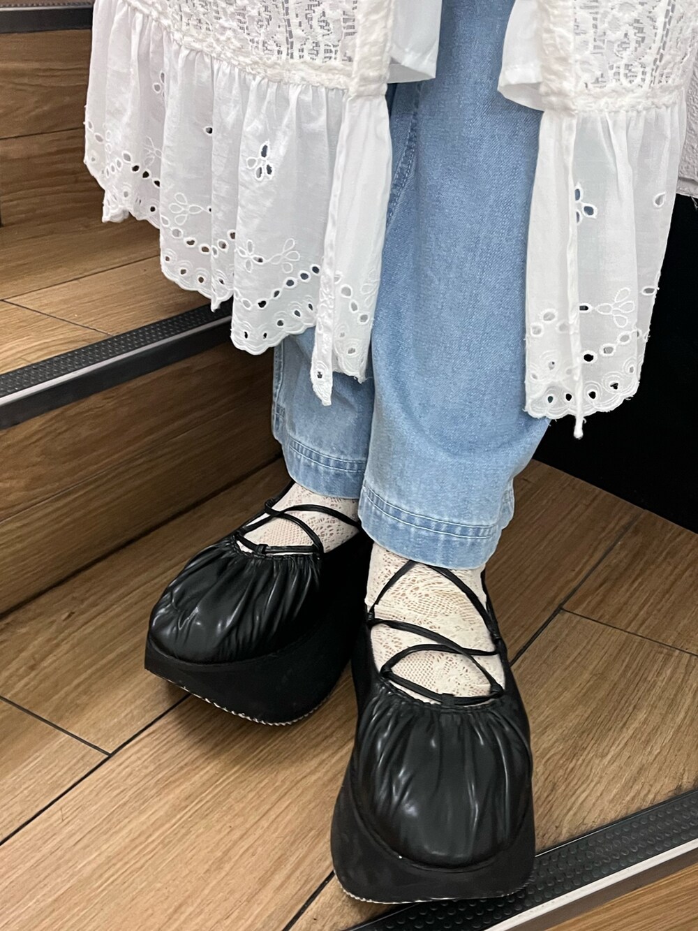 ホワイト系のトレンチコート、グリーン系のTシャツ/カットソー、ブラック系のバレエシューズを着用したレディースの春コーディネートの6枚目の写真