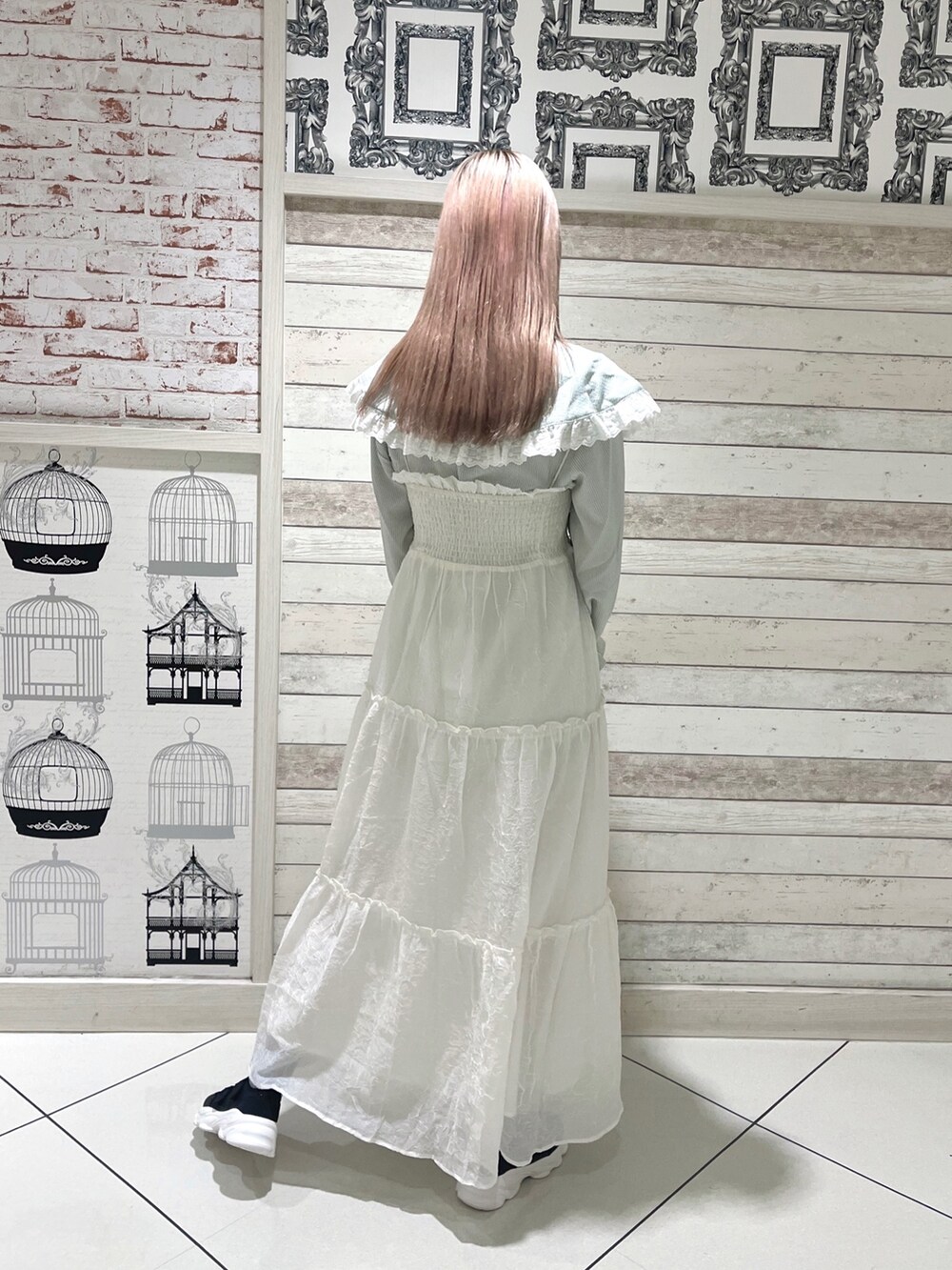グリーン系のシャツ/ブラウス、ホワイト系のワンピース、ブラック系のスニーカーを着用したレディースの春コーディネートの4枚目の写真
