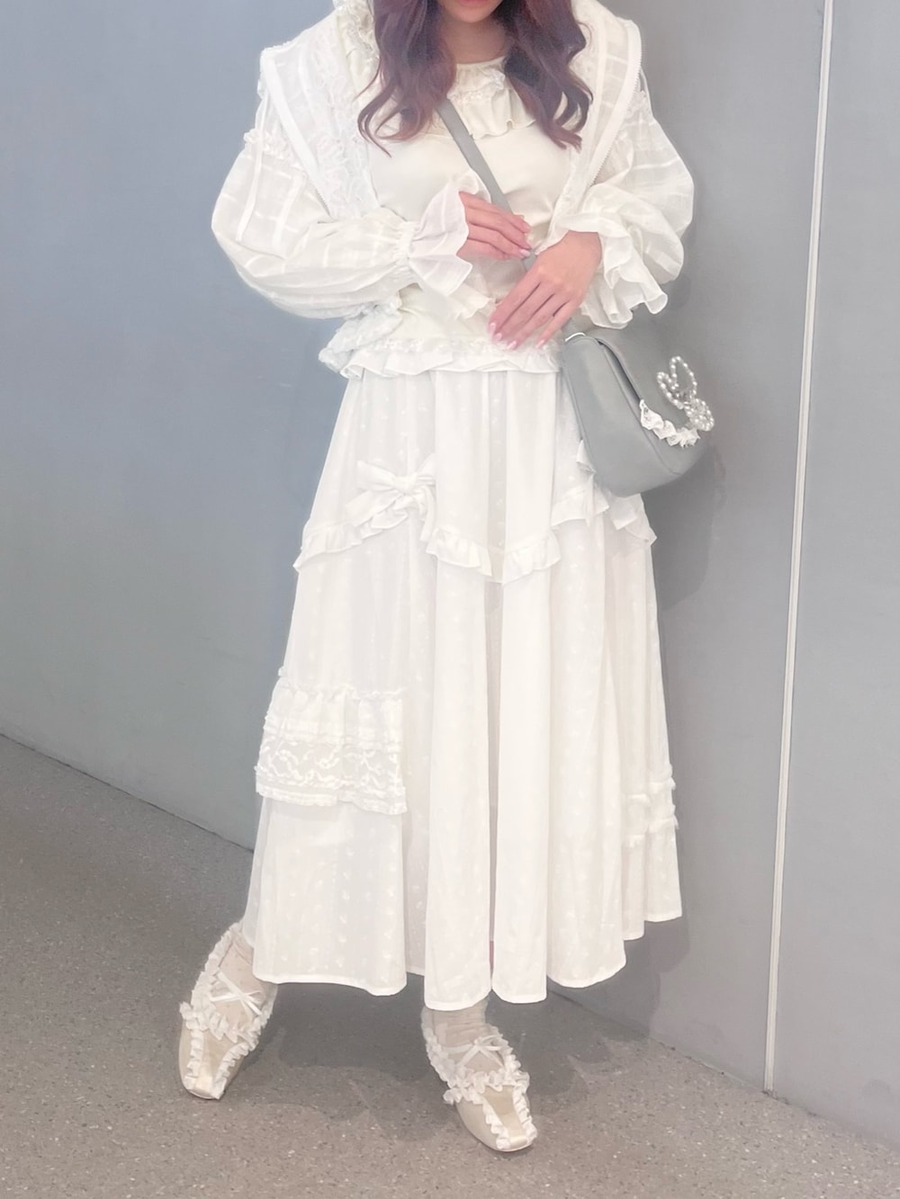 ホワイト系のスカート、ホワイト系のバレエシューズ、ブルー系のショルダーバッグを着用したレディースの春コーディネートの2枚目の写真