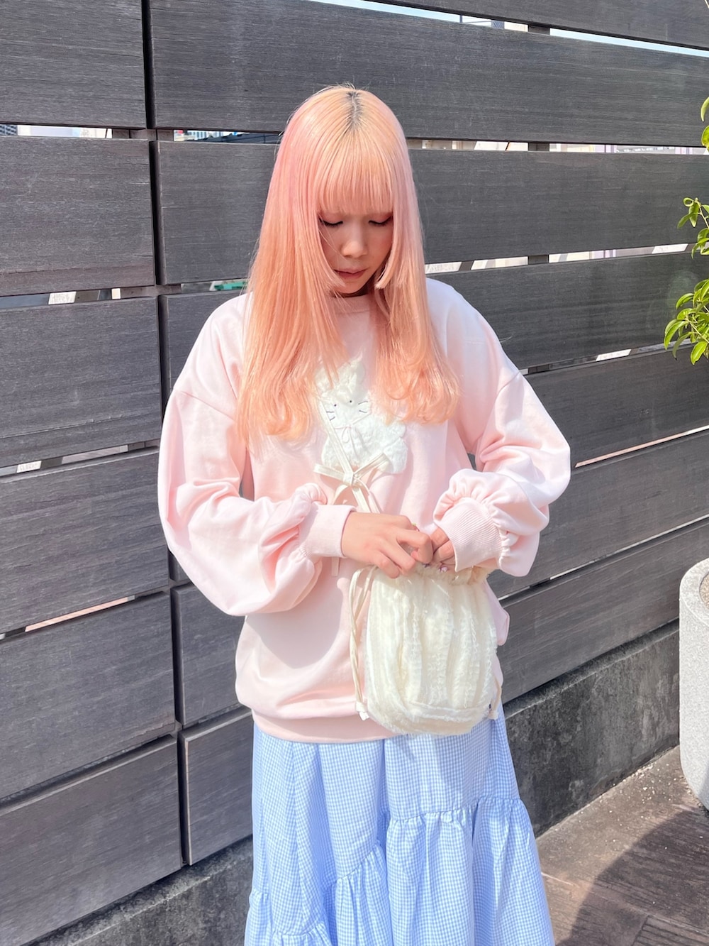 ピンク系のスウェット、ブルー系のスカート、ホワイト系のバレエシューズを着用したレディースの春コーディネートの5枚目の写真