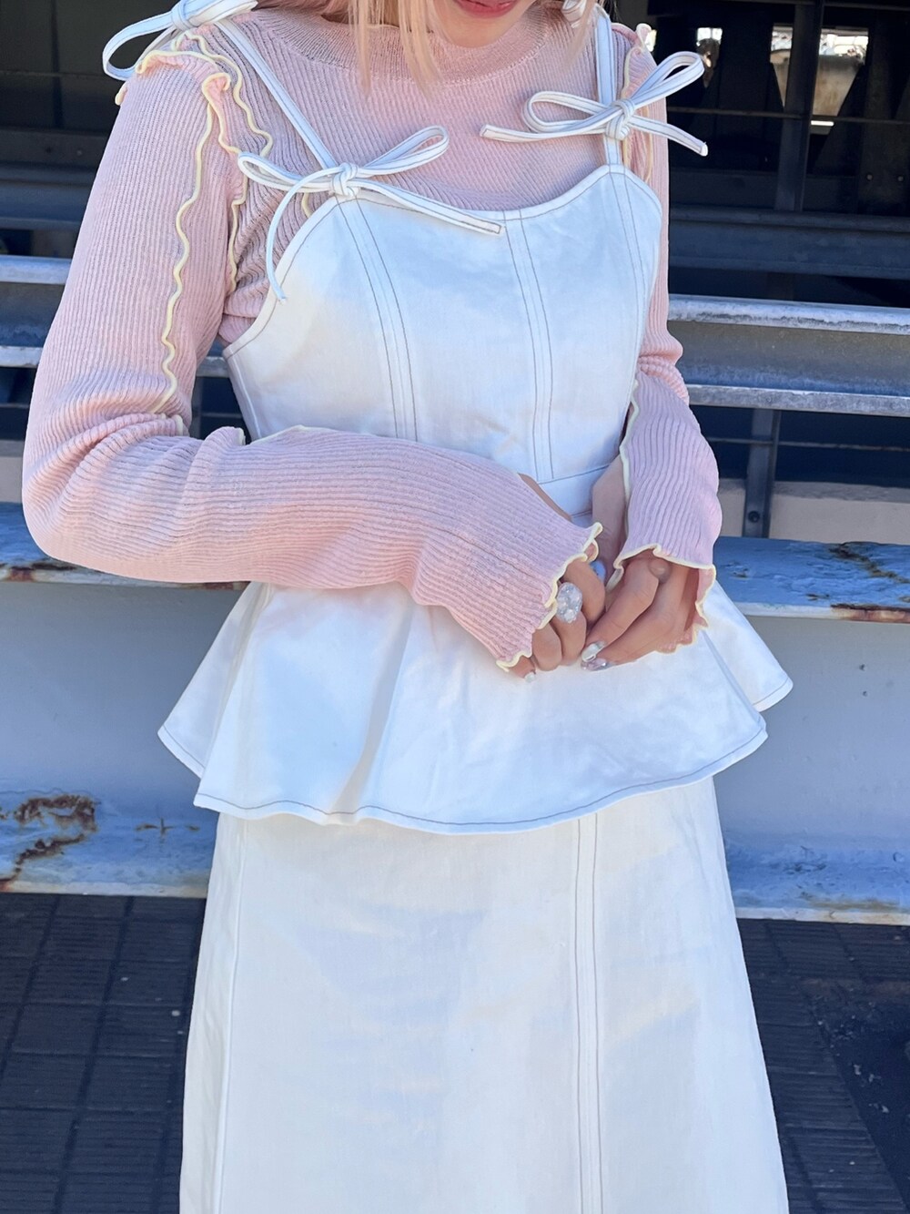 ピンク系のTシャツ/カットソー、ホワイト系のワンピース、ホワイト系のスニーカーを着用したレディースの冬コーディネートの5枚目の写真