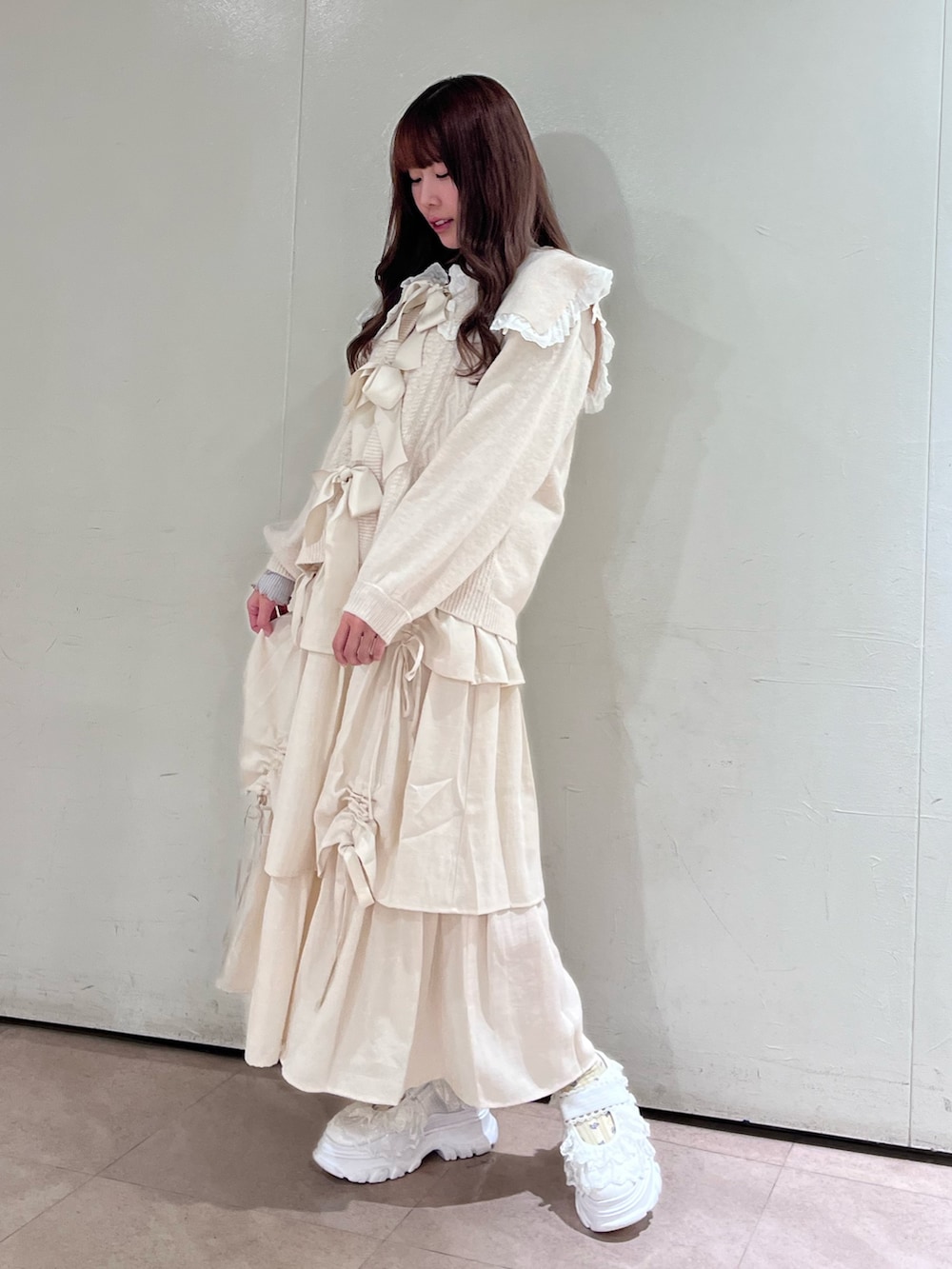 ホワイト系のカーディガン/ボレロ、グレー系のニット/セーター、ホワイト系のスカートを着用したレディースの秋コーディネートの2枚目の写真