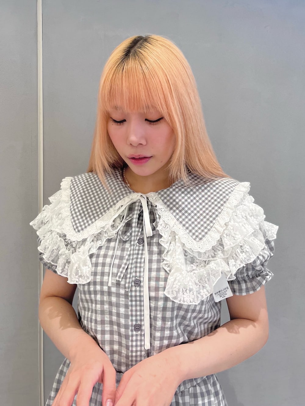 グレー系のシャツ/ブラウス、グレー系のスカート、ホワイト系のサンダルを着用したレディースの春コーディネートの4枚目の写真