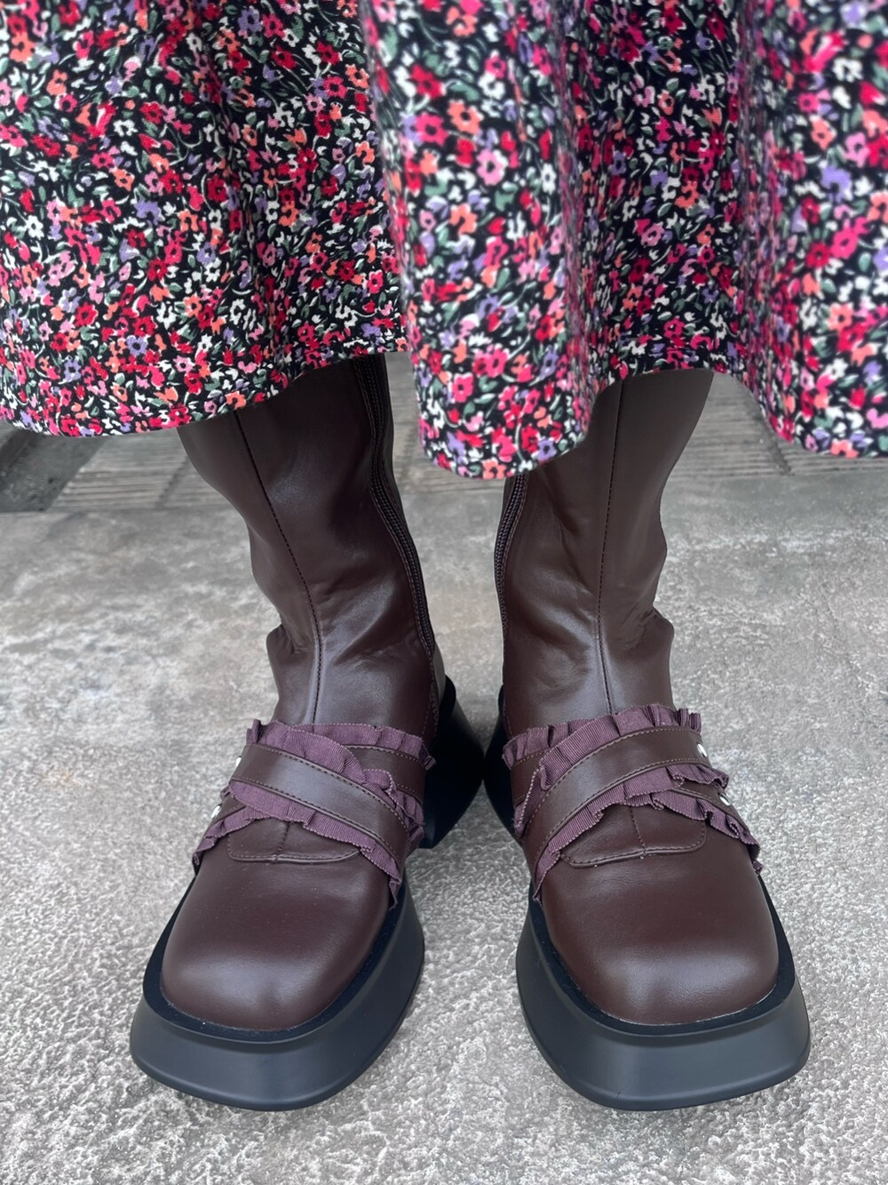 ブラック系のカーディガン/ボレロ、ピンク系のワンピース、ブラウン系のブーツを着用したレディースの秋コーディネートの9枚目の写真