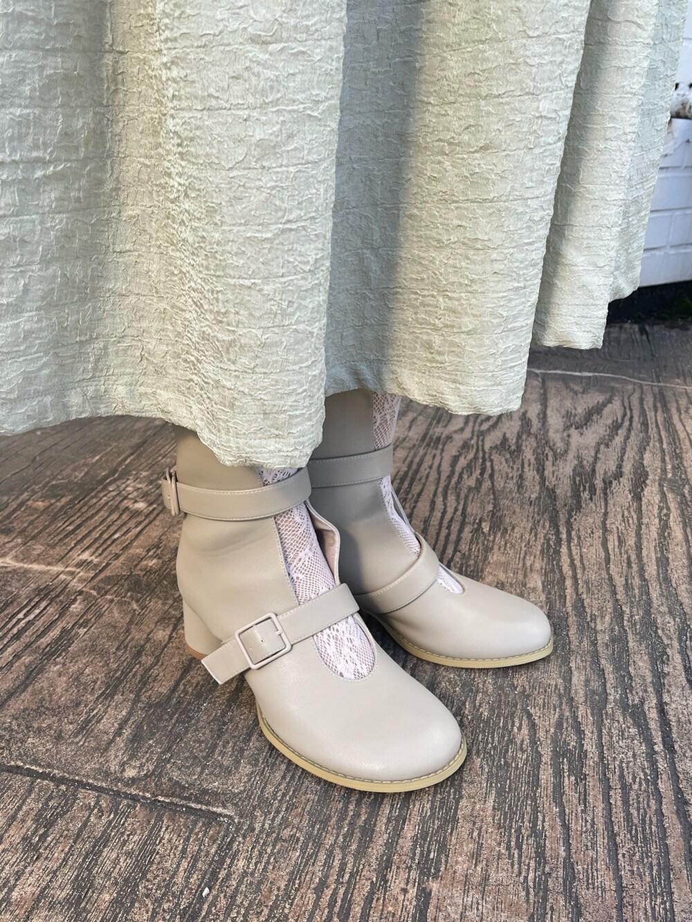 ベージュ系のブーツ、グリーン系のワンピース、ホワイト系のニット/セーターを着用したレディースの冬コーディネートの8枚目の写真