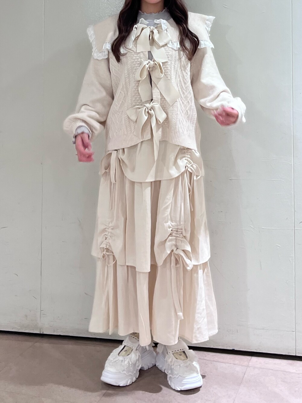 ホワイト系のカーディガン/ボレロ、グレー系のニット/セーター、ホワイト系のスカートを着用したレディースの秋コーディネートの3枚目の写真