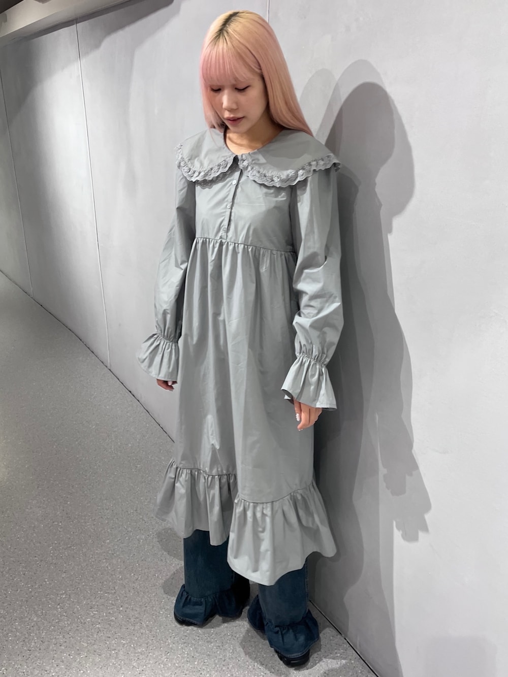 ブラウン系のノーカラーコート、グレー系のワンピース、ブルー系のデニムパンツを着用したレディースの冬コーディネートの3枚目の写真