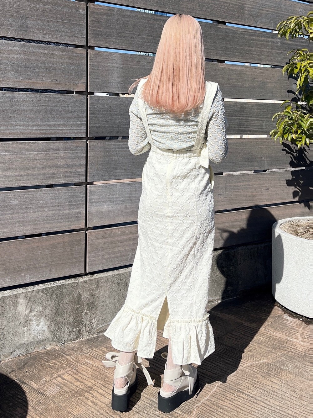 ブルー系のTシャツ/カットソー、ホワイト系のスカート、ホワイト系のパンプスを着用したレディースの冬コーディネートの3枚目の写真