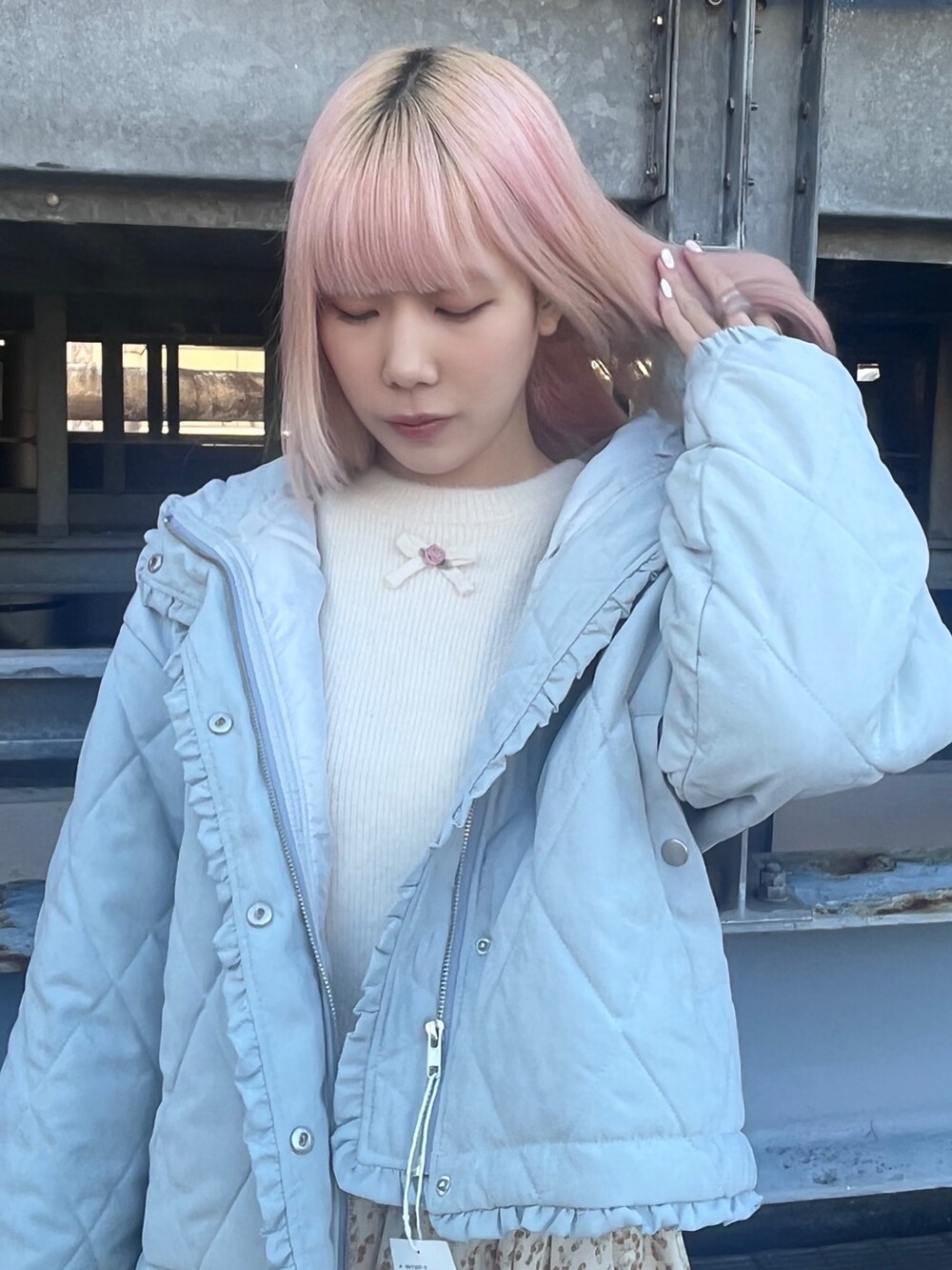 ブルー系のダウンジャケット/コート、ホワイト系のニット/セーター、ホワイト系のスカートを着用したレディースの冬コーディネートの6枚目の写真