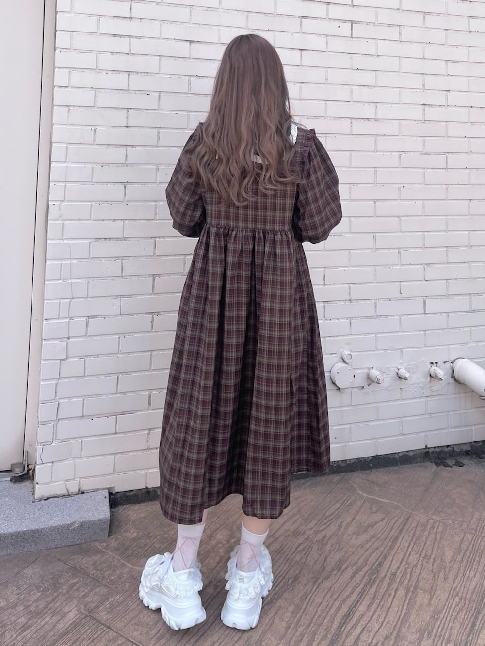 レッド系のワンピース、ホワイト系のサンダルを着用したレディースの秋コーディネートの3枚目の写真