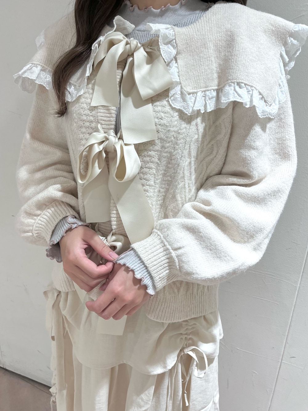 ホワイト系のカーディガン/ボレロ、グレー系のニット/セーター、ホワイト系のスカートを着用したレディースの秋コーディネートの7枚目の写真