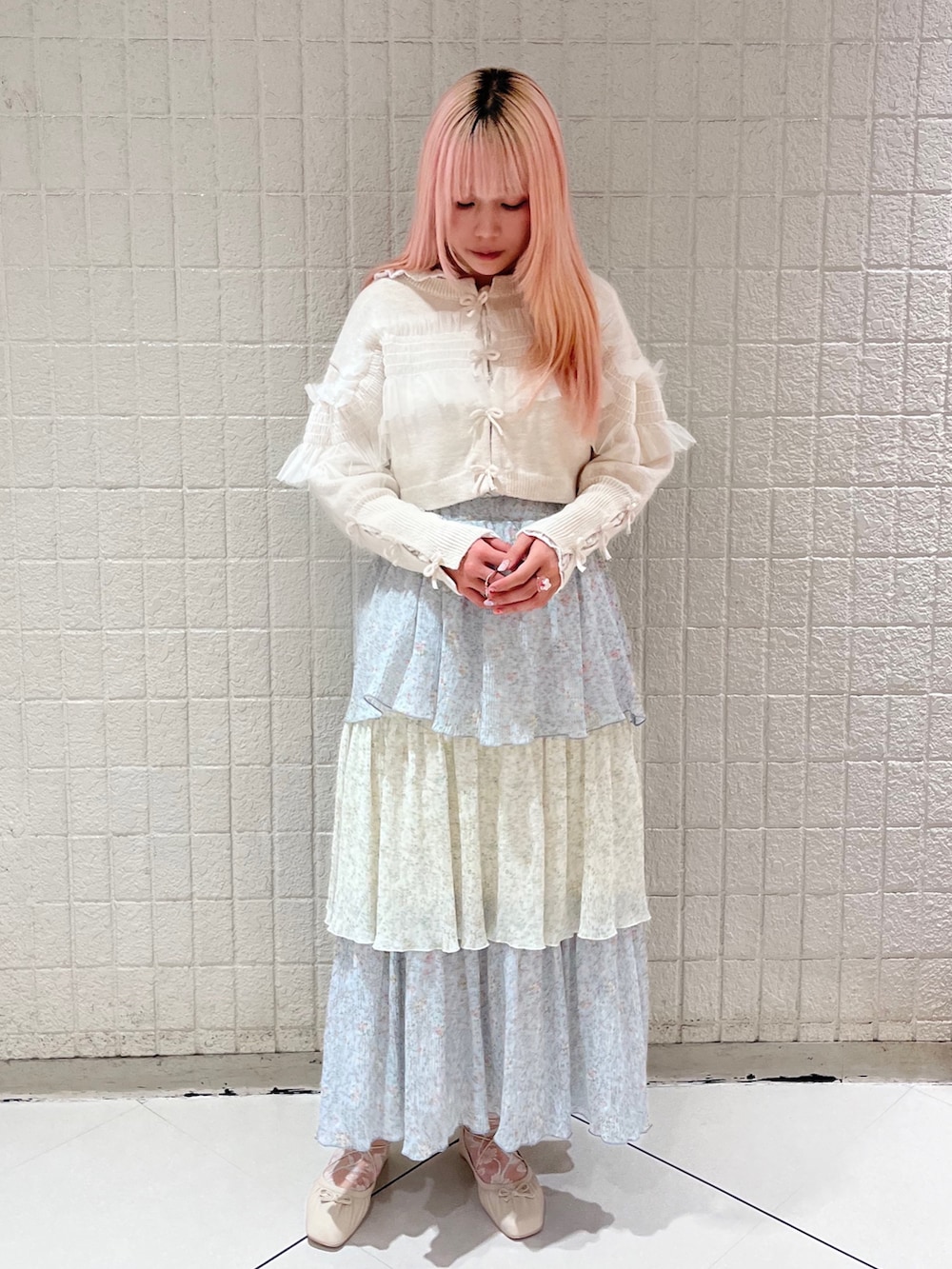 ブルー系のスカート、ホワイト系のカーディガン/ボレロ、ホワイト系のTシャツ/カットソーを着用したレディースの秋コーディネートの2枚目の写真