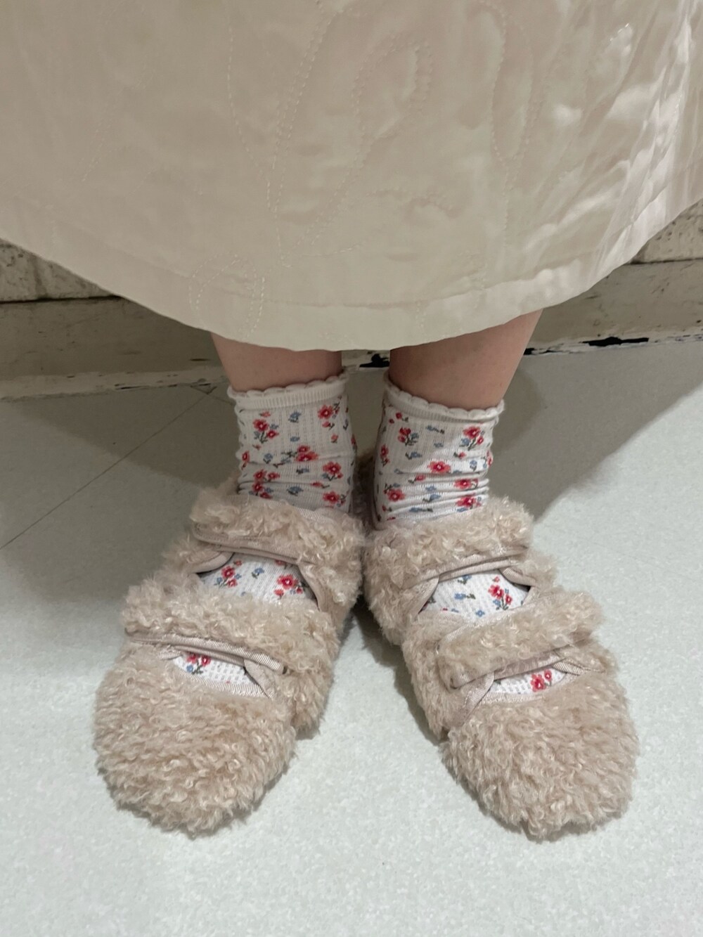 ピンク系のニット/セーター、ホワイト系のダウンベスト、ホワイト系のワンピースを着用したレディースの秋コーディネートの7枚目の写真
