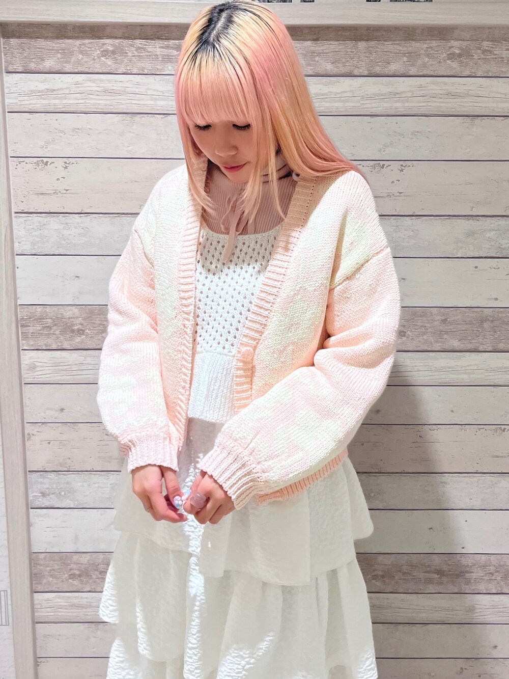 ピンク系のニット/セーター、ホワイト系のキャミソール、ホワイト系のスカートを着用したレディースの冬コーディネートの5枚目の写真