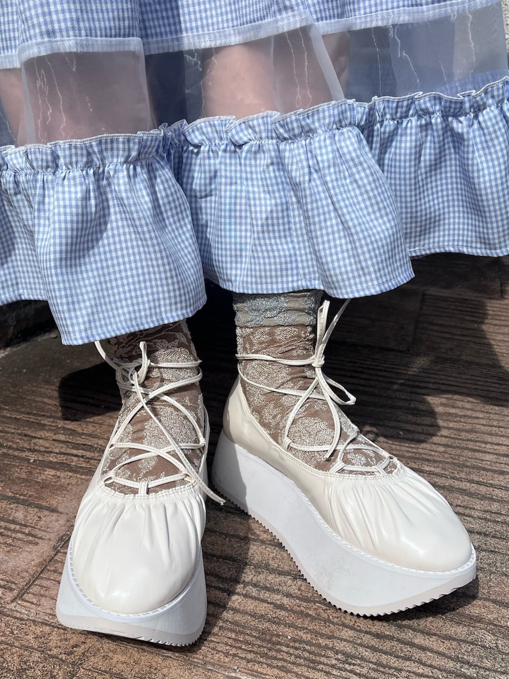 ピンク系のスウェット、ブルー系のスカート、ホワイト系のバレエシューズを着用したレディースの春コーディネートの9枚目の写真