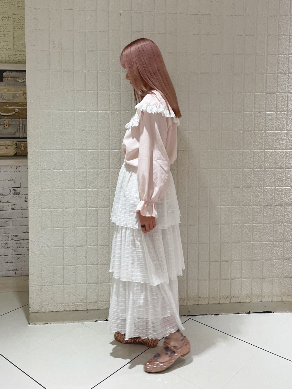 ピンク系のシャツ/ブラウス、ホワイト系のスカート、ピンク系のパンプスを着用したレディースの春コーディネートの2枚目の写真
