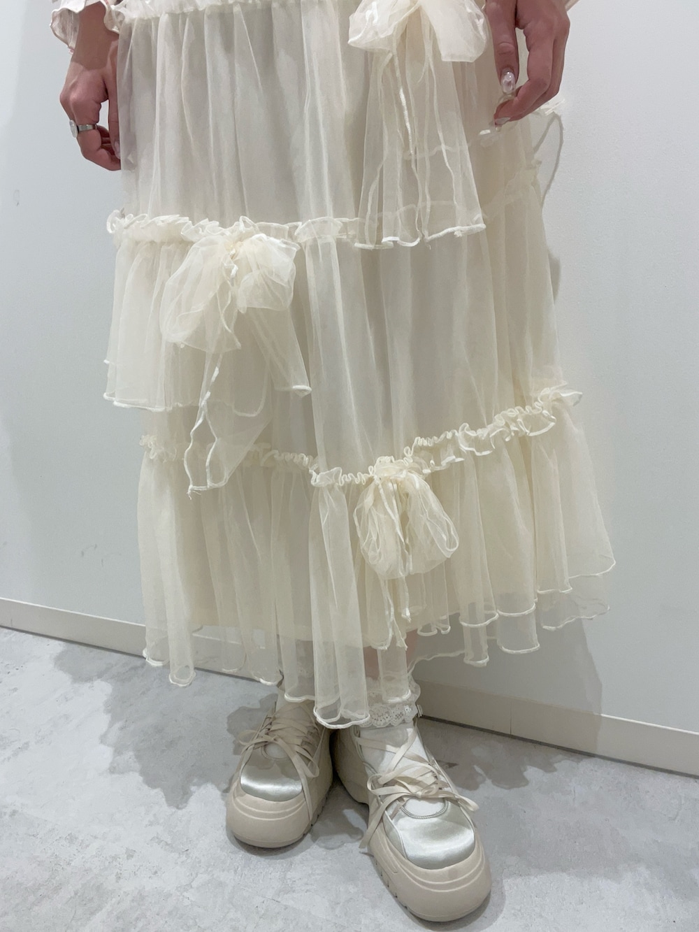 ホワイト系のスカート、ホワイト系のカーディガン/ボレロ、ピンク系のTシャツ/カットソーを着用したレディースの冬コーディネートの7枚目の写真