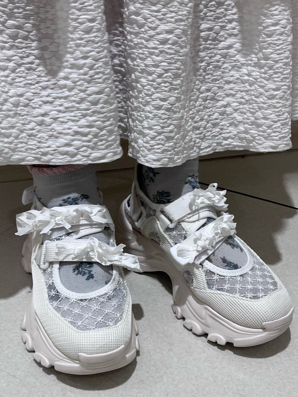 ピンク系のニット/セーター、ホワイト系のキャミソール、ホワイト系のスカートを着用したレディースの冬コーディネートの10枚目の写真