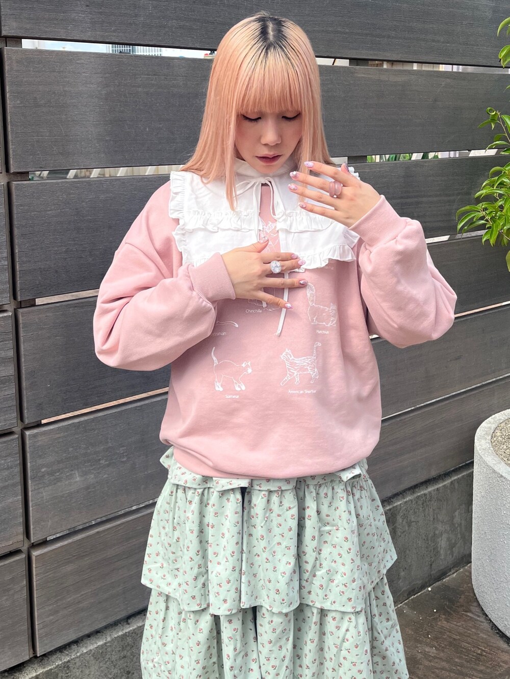 ホワイト系のシャツ/ブラウス、ピンク系のスウェット、グリーン系のジャンパースカートを着用したレディースの秋コーディネートの5枚目の写真