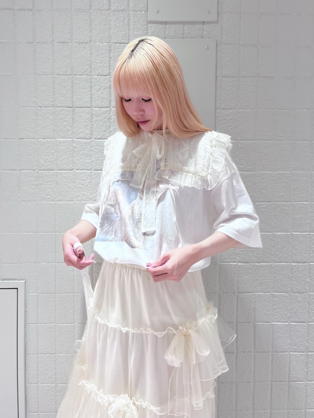 ホワイト系のTシャツ/カットソー、ホワイト系のスカート、ホワイト系のトートバッグを着用したレディースの夏コーディネートの3枚目の写真