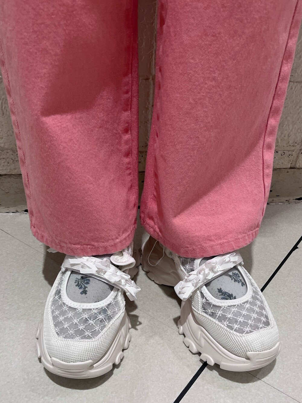 ホワイト系のスウェット、ピンク系のTシャツ/カットソー、ピンク系のデニムパンツを着用したレディースの冬コーディネートの7枚目の写真