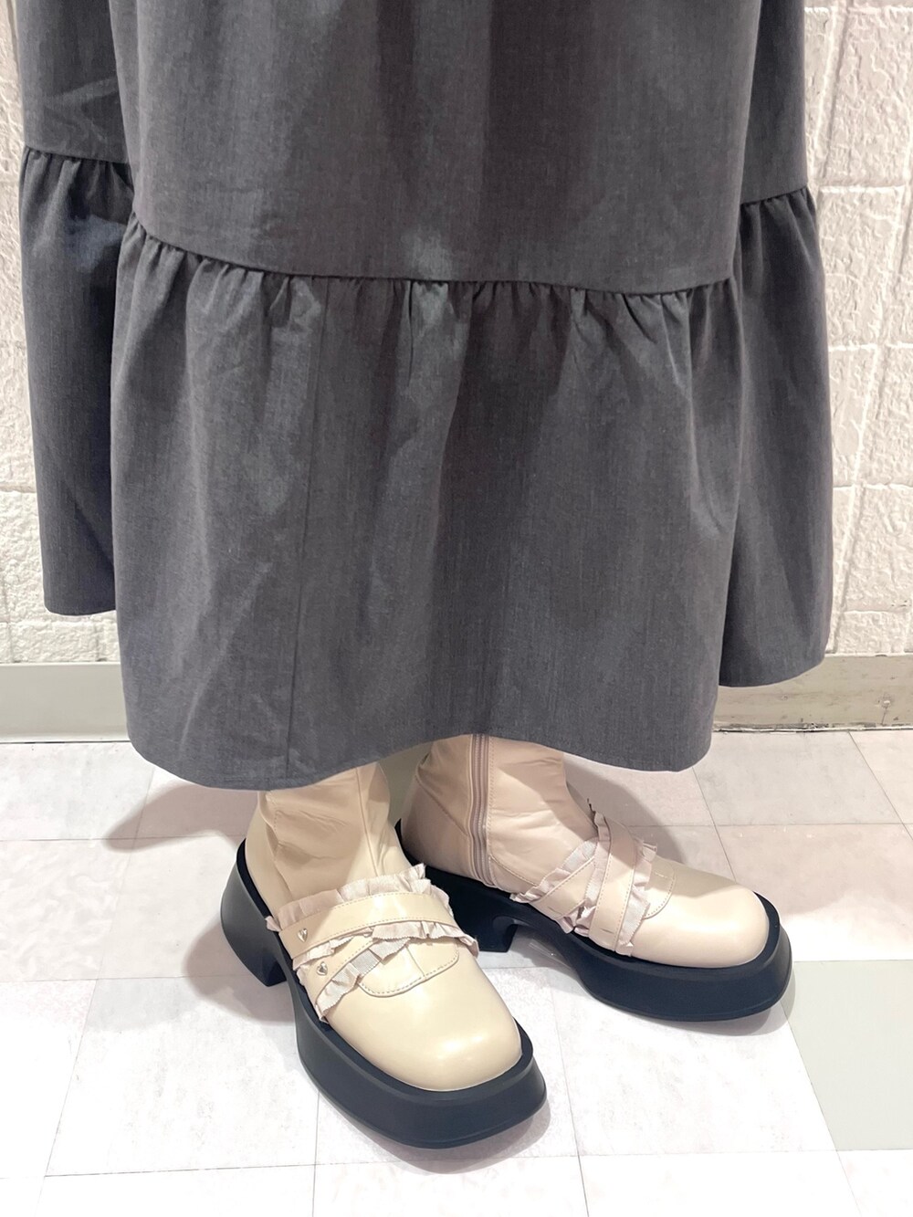 ホワイト系のニット/セーター、グレー系のワンピース、ホワイト系のハンドバッグを着用したレディースの秋コーディネートの8枚目の写真