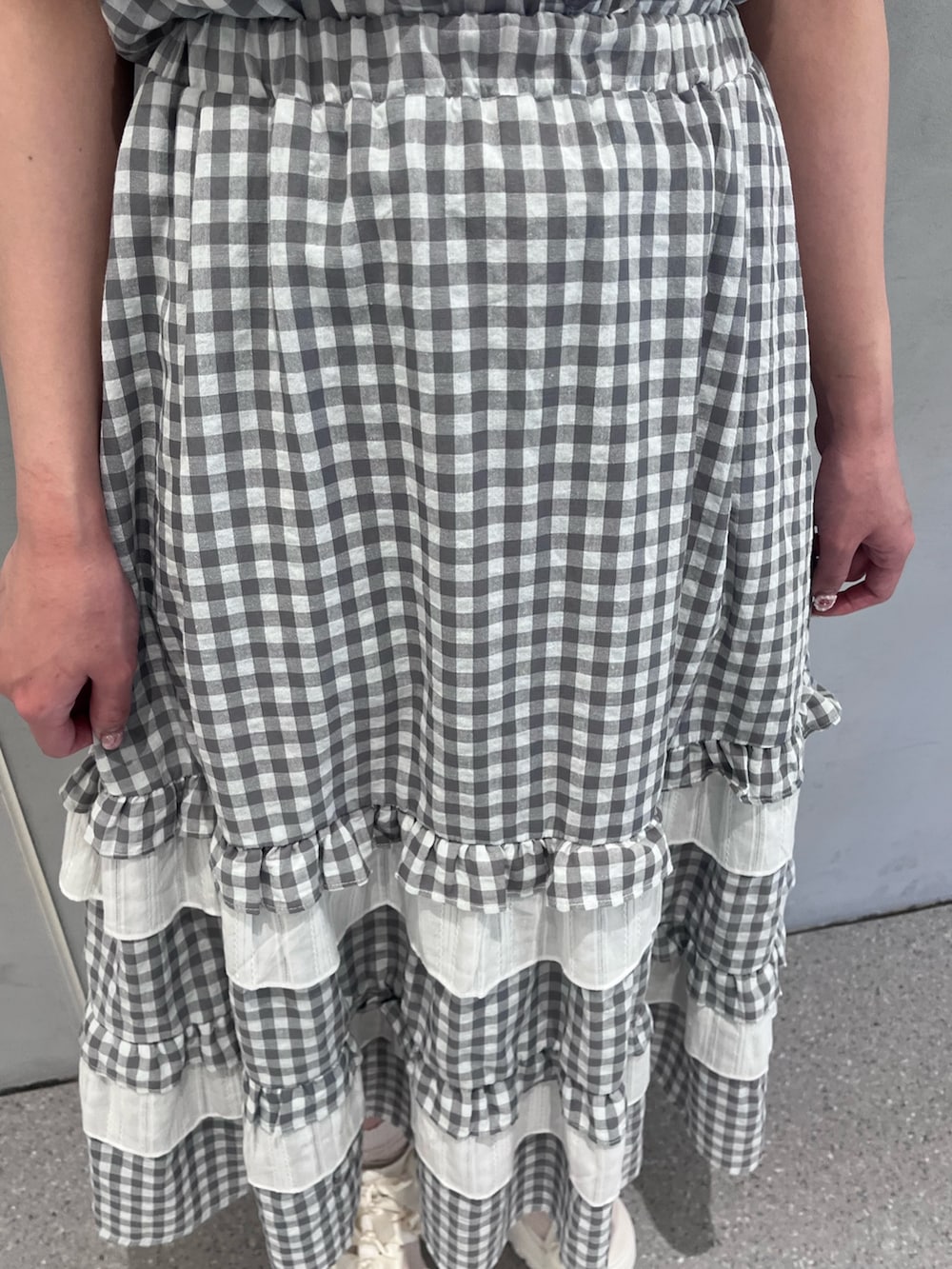 グレー系のシャツ/ブラウス、グレー系のスカート、ホワイト系のサンダルを着用したレディースの春コーディネートの6枚目の写真