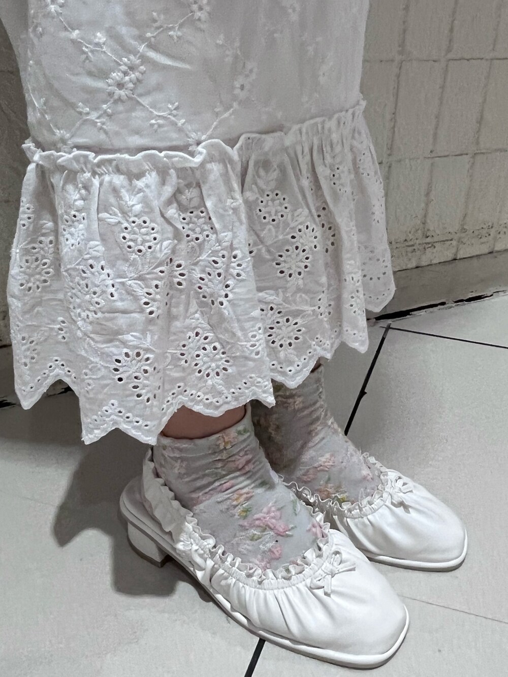 ホワイト系のキャミソール、ホワイト系のスカート、ホワイト系のパンプスを着用したレディースの春コーディネートの10枚目の写真