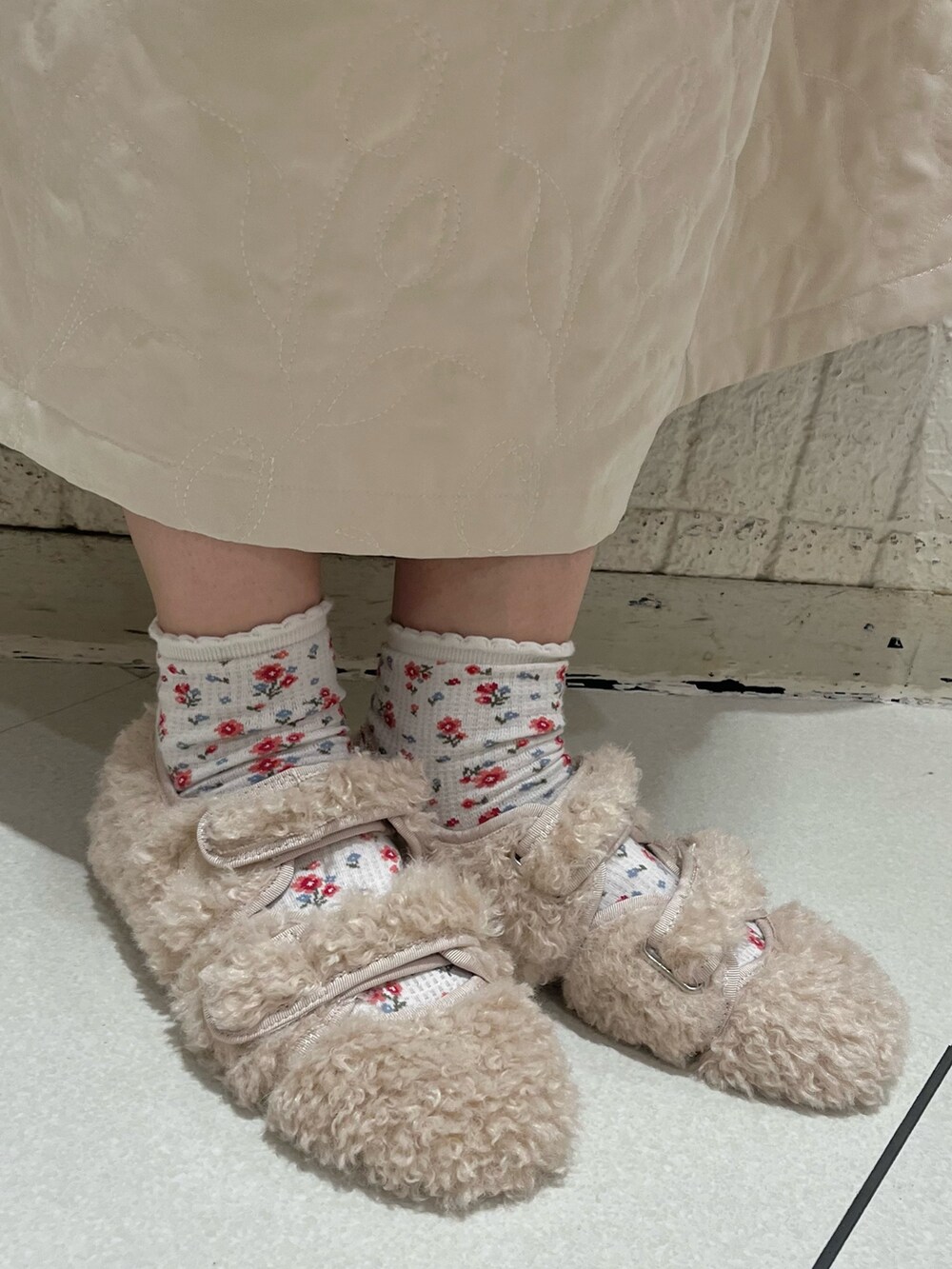 ピンク系のニット/セーター、ホワイト系のダウンベスト、ホワイト系のワンピースを着用したレディースの秋コーディネートの8枚目の写真