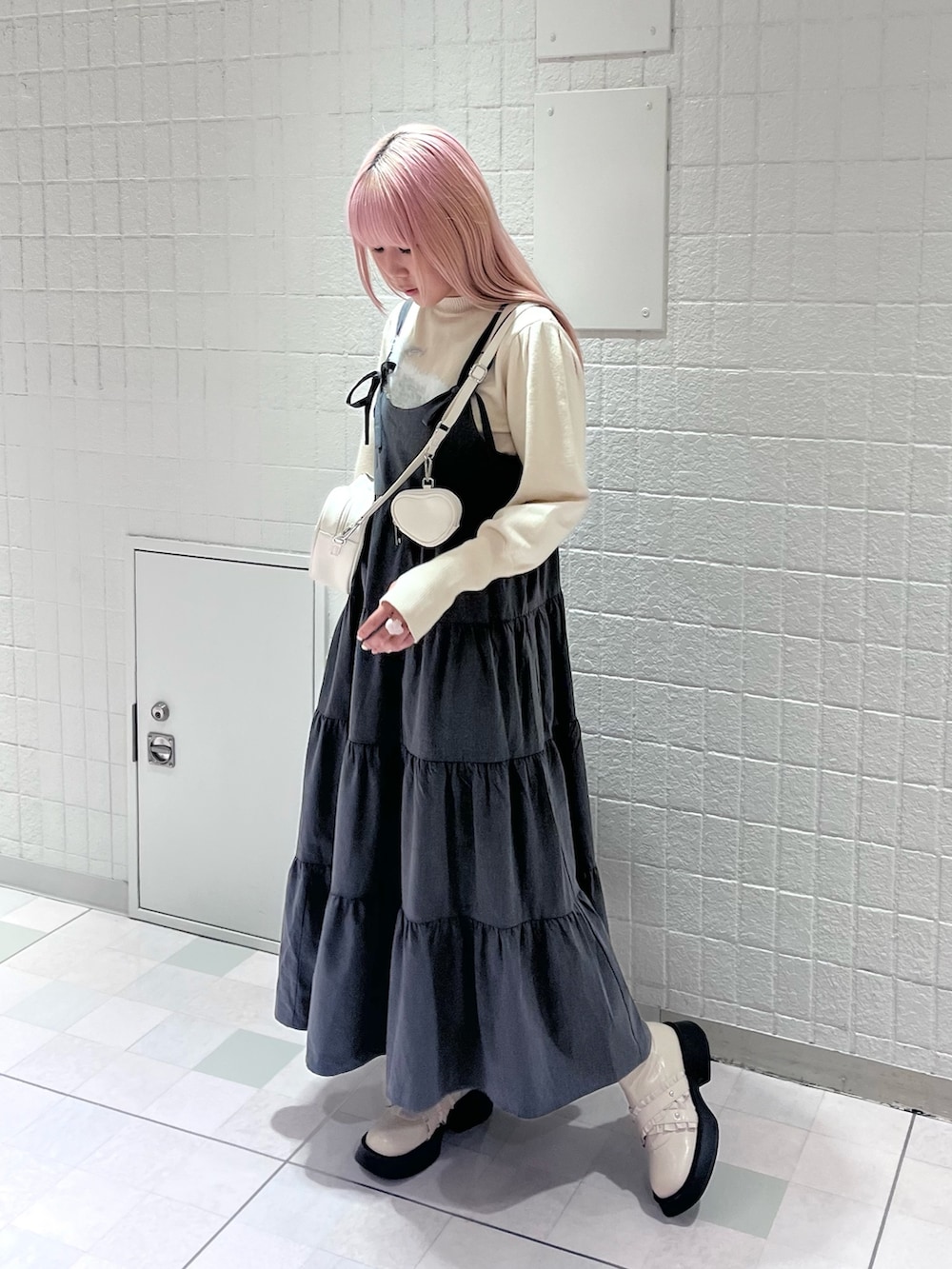 ホワイト系のニット/セーター、グレー系のワンピース、ホワイト系のハンドバッグを着用したレディースの秋コーディネートの2枚目の写真