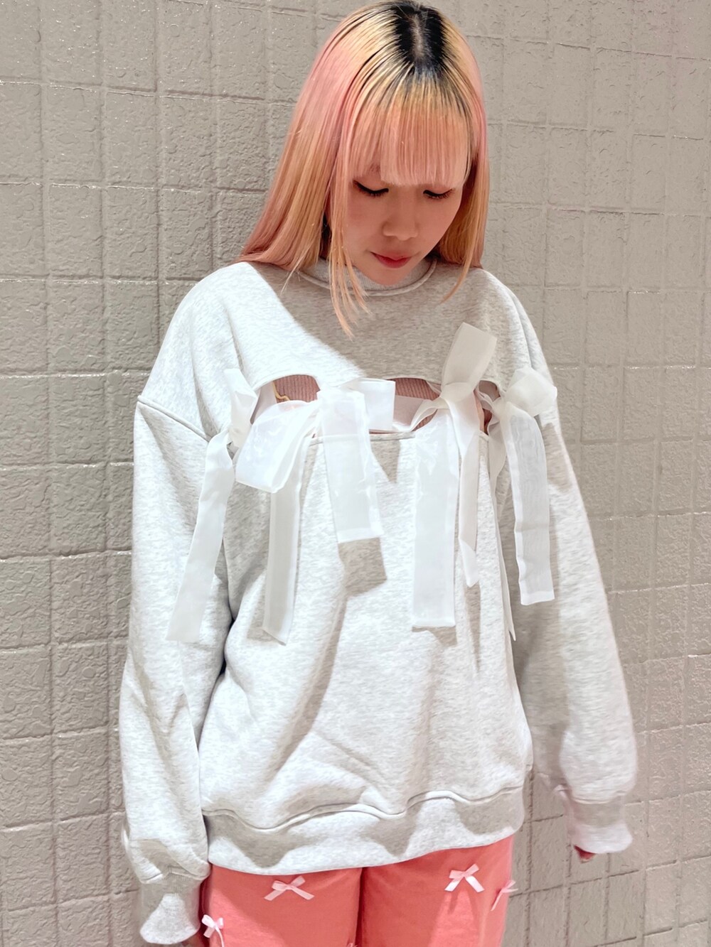 ホワイト系のスウェット、ピンク系のTシャツ/カットソー、ピンク系のデニムパンツを着用したレディースの冬コーディネートの5枚目の写真