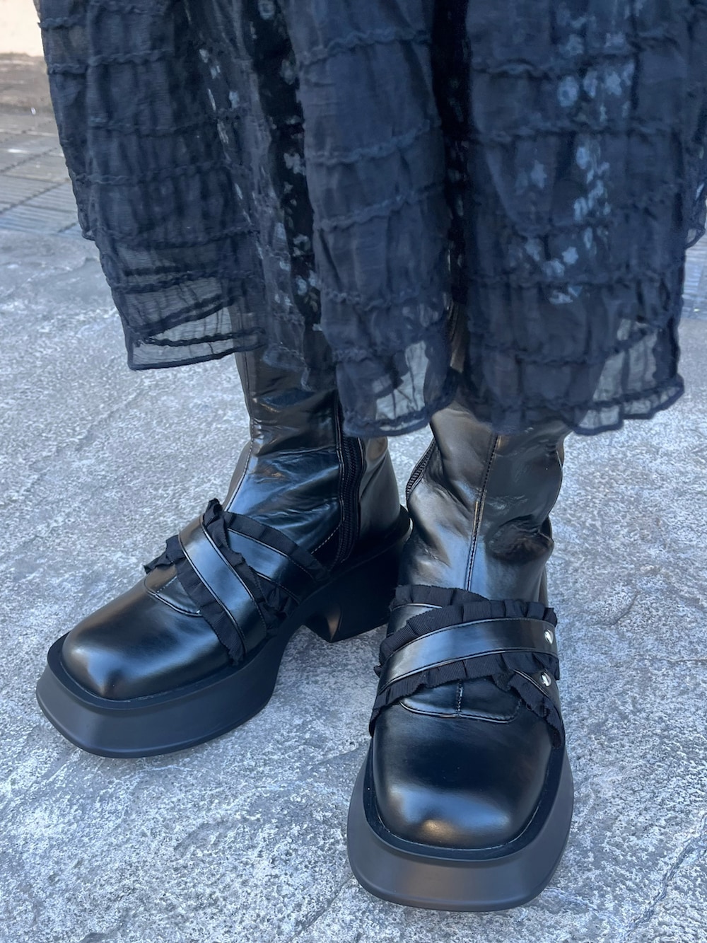 ブラック系のチェスターコート、ブラック系のワンピース、ブラック系のワンピースを着用したレディースの冬コーディネートの7枚目の写真