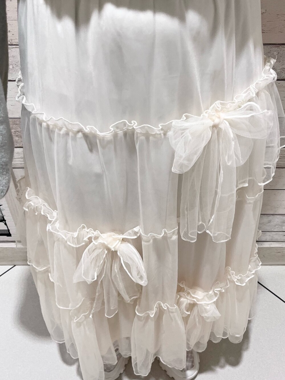 グレー系のカーディガン/ボレロ、ホワイト系のTシャツ/カットソー、ホワイト系のスカートを着用したレディースの秋コーディネートの8枚目の写真