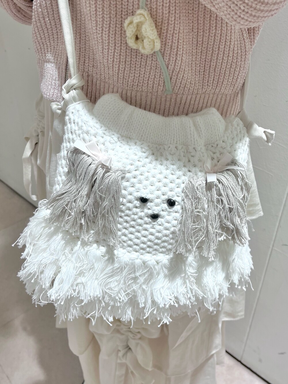 ホワイト系のスカート、ベージュ系のショルダーバッグ、ピンク系のカーディガン/ボレロを着用したレディースの秋コーディネートの8枚目の写真