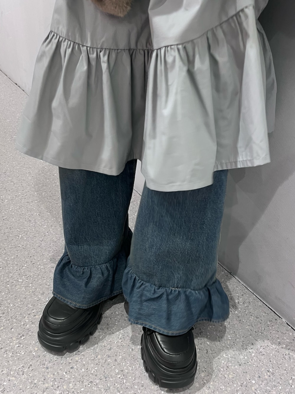 ブラウン系のノーカラーコート、グレー系のワンピース、ブルー系のデニムパンツを着用したレディースの冬コーディネートの10枚目の写真