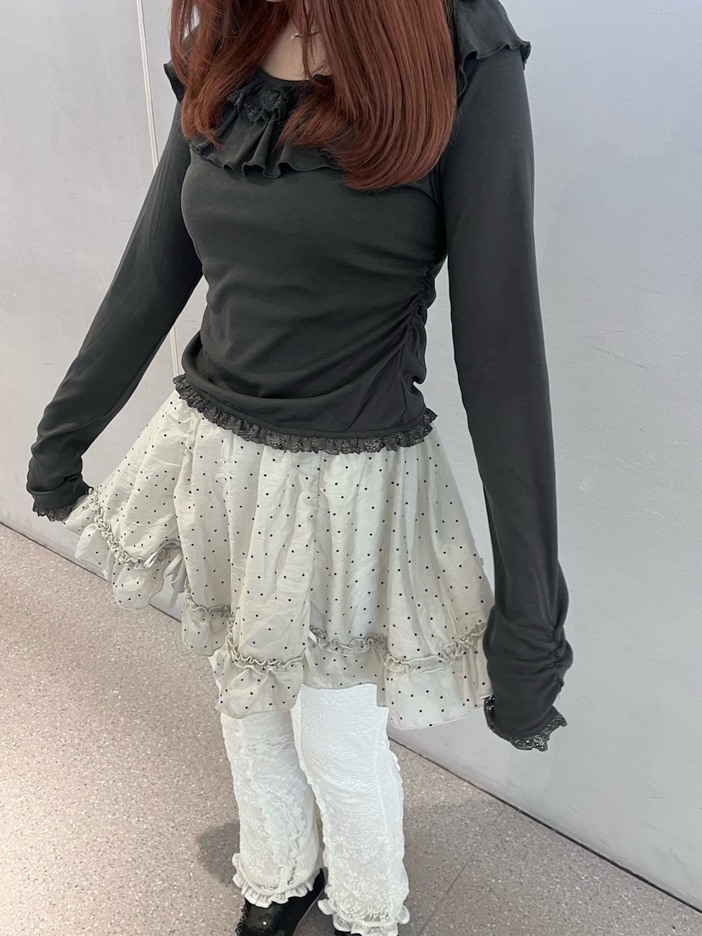 グレー系のTシャツ/カットソー、グレー系のスカート、ホワイト系のその他パンツを着用したレディースの冬コーディネートの6枚目の写真