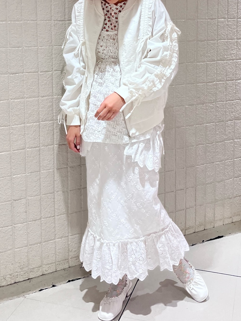 ホワイト系のキャミソール、ホワイト系のスカート、ホワイト系のパンプスを着用したレディースの春コーディネートの4枚目の写真