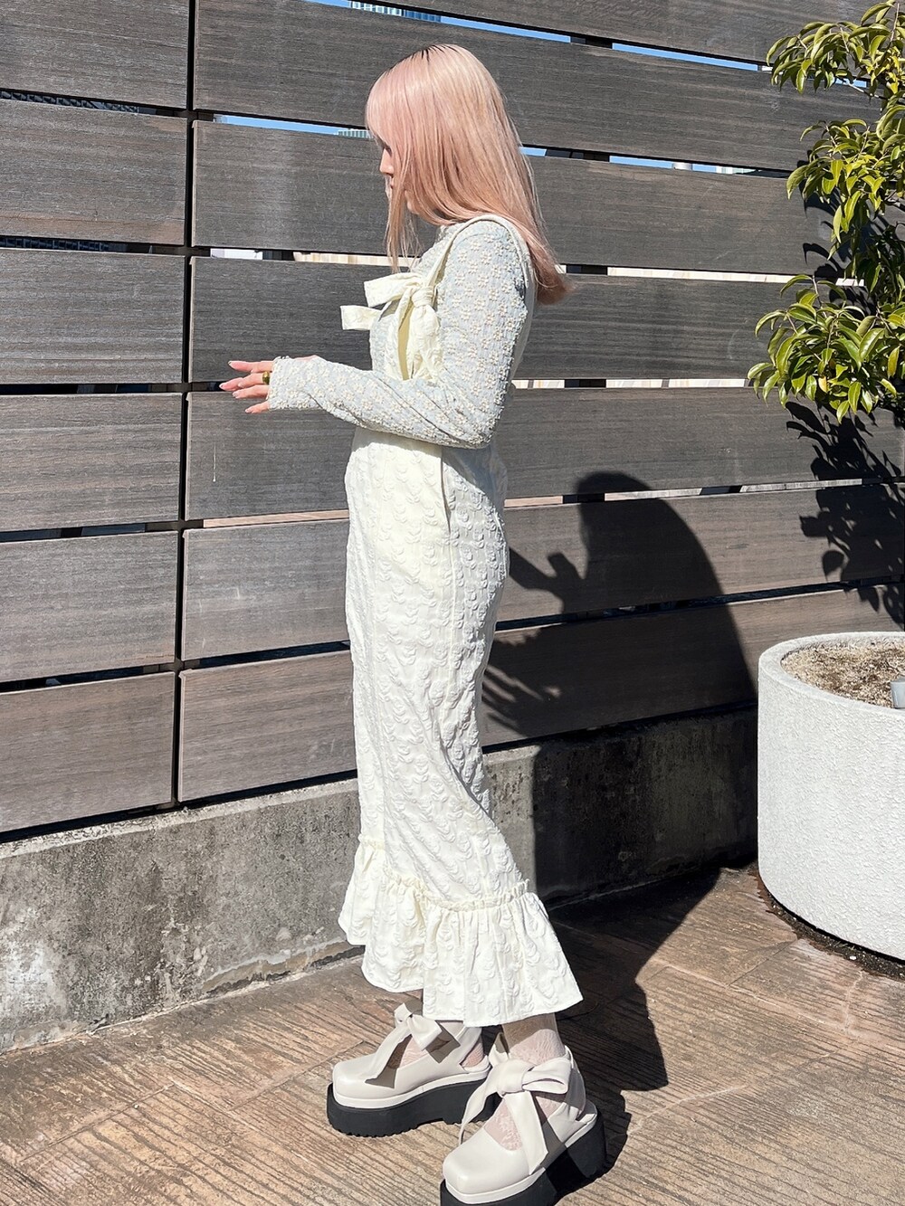 ブルー系のTシャツ/カットソー、ホワイト系のスカート、ホワイト系のパンプスを着用したレディースの冬コーディネートの4枚目の写真