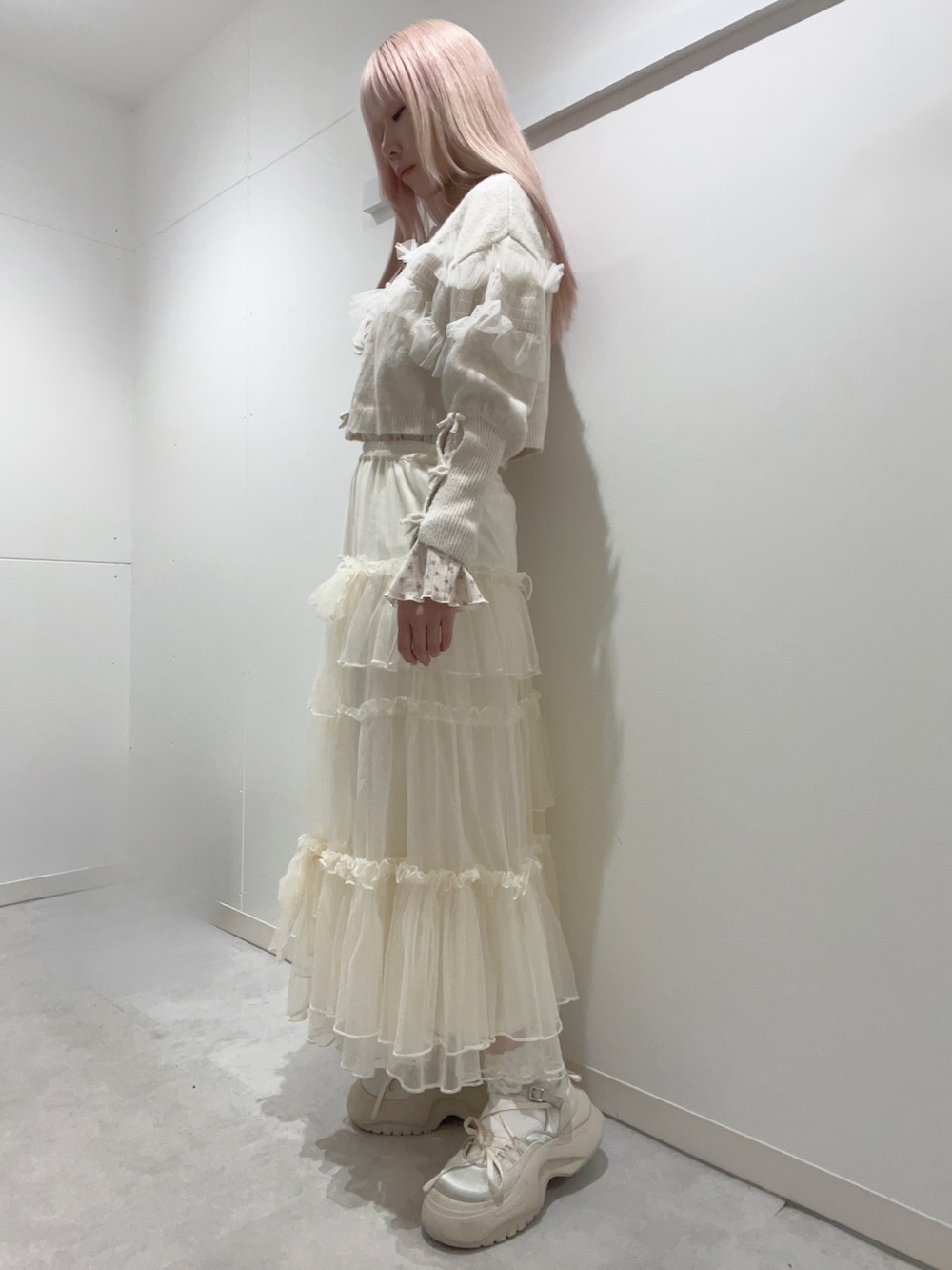 ホワイト系のスカート、ホワイト系のカーディガン/ボレロ、ピンク系のTシャツ/カットソーを着用したレディースの冬コーディネートの2枚目の写真