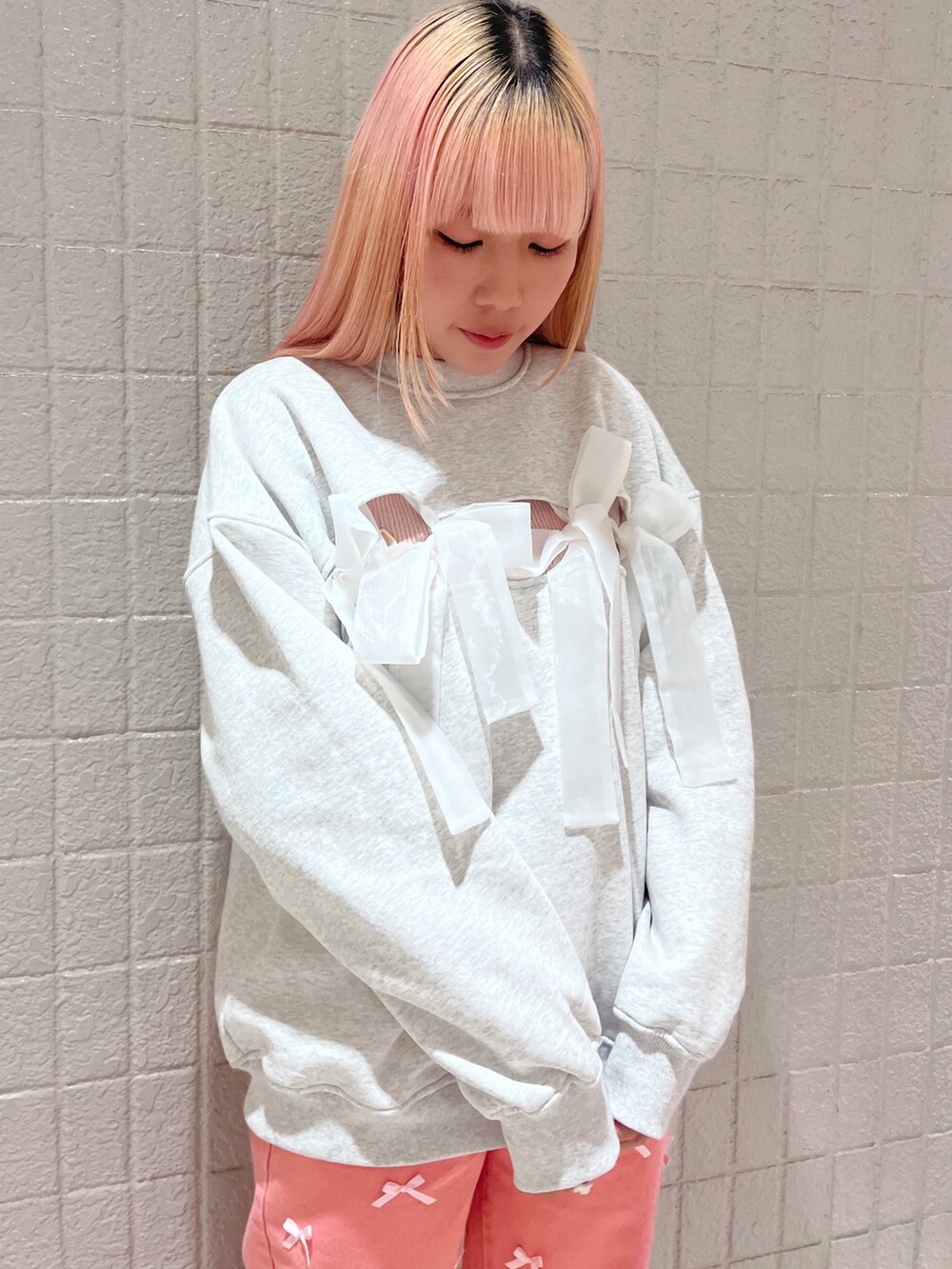 ホワイト系のスウェット、ピンク系のTシャツ/カットソー、ピンク系のデニムパンツを着用したレディースの冬コーディネートの4枚目の写真