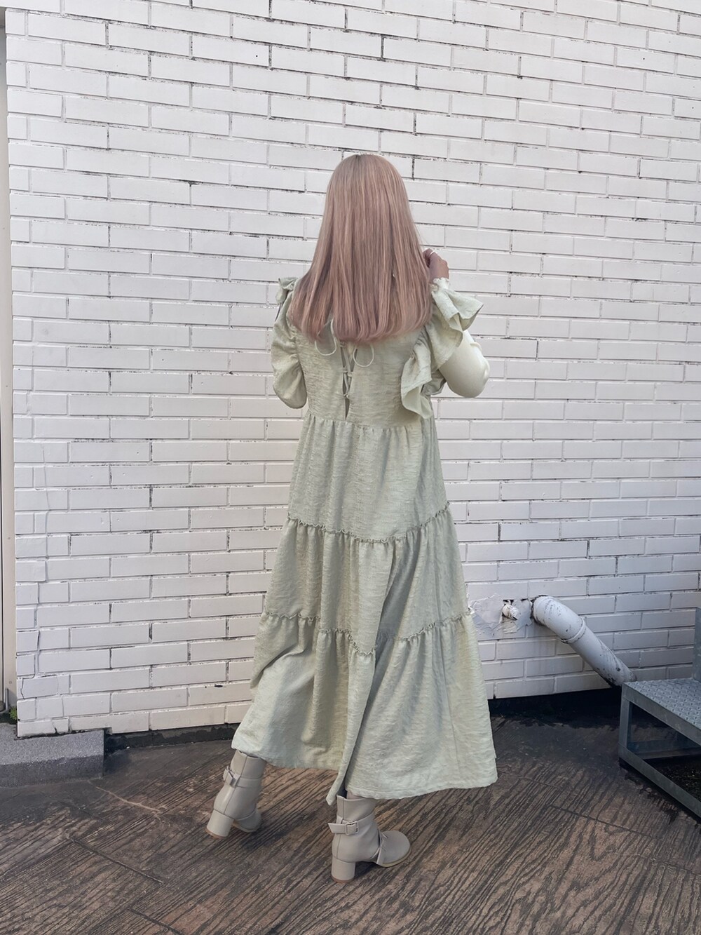 ベージュ系のブーツ、グリーン系のワンピース、ホワイト系のニット/セーターを着用したレディースの冬コーディネートの4枚目の写真