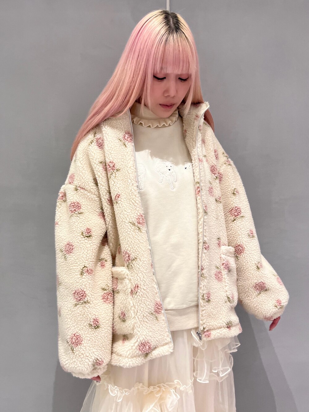 ピンク系のブルゾン、ベージュ系のスウェット、ホワイト系のニット/セーターを着用したレディースの冬コーディネートの3枚目の写真